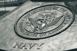 Detailed view of the United States Navy emblem on a monument in Washington D.C., showcasing naval heritage.