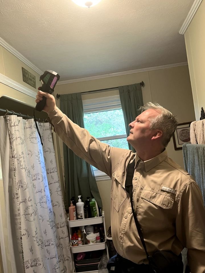 John Griffith using thermal imaging equipment to inspect a bathroom ceiling in a Crossville, Tennessee home.